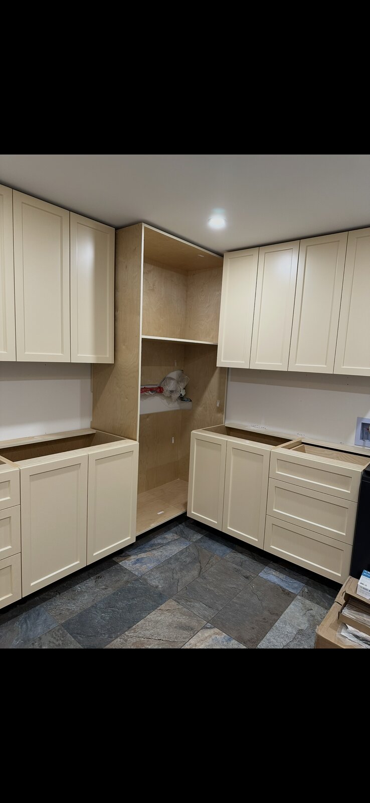 Custom kitchen cabinetry install with cream shaker-style cabinets in a corner configuration