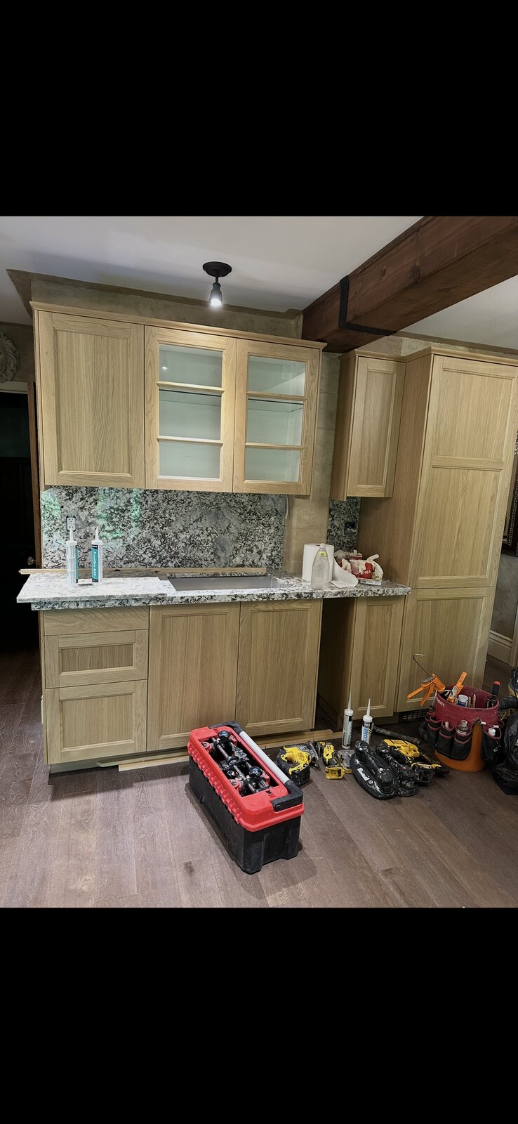 Custom wet bar cabinetry with granite counter and undermount sink