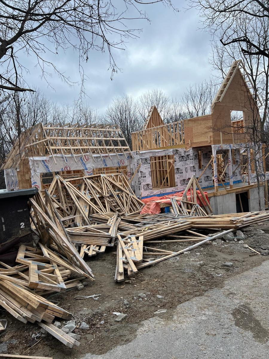 Roof trusses and framing lumber staged on a custom home job site